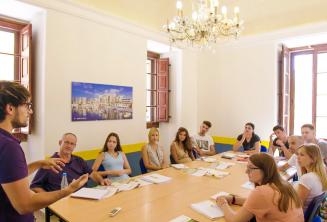 英語を学ぶ生徒たちでいっぱいの教室で話す教師